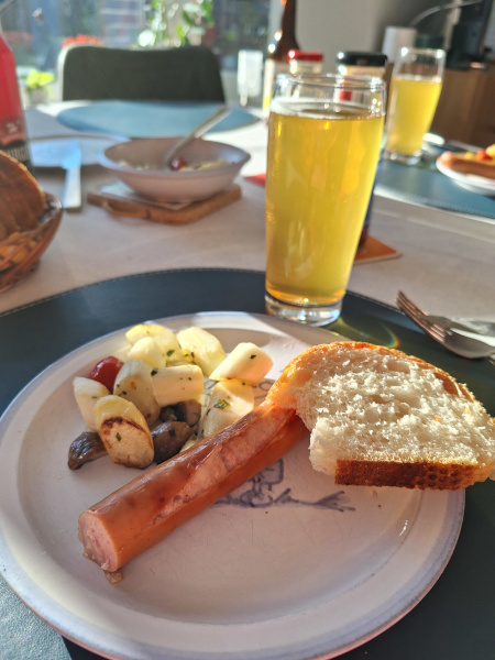 Teller mit Bratwurst, Salat und Knoblauchbrot